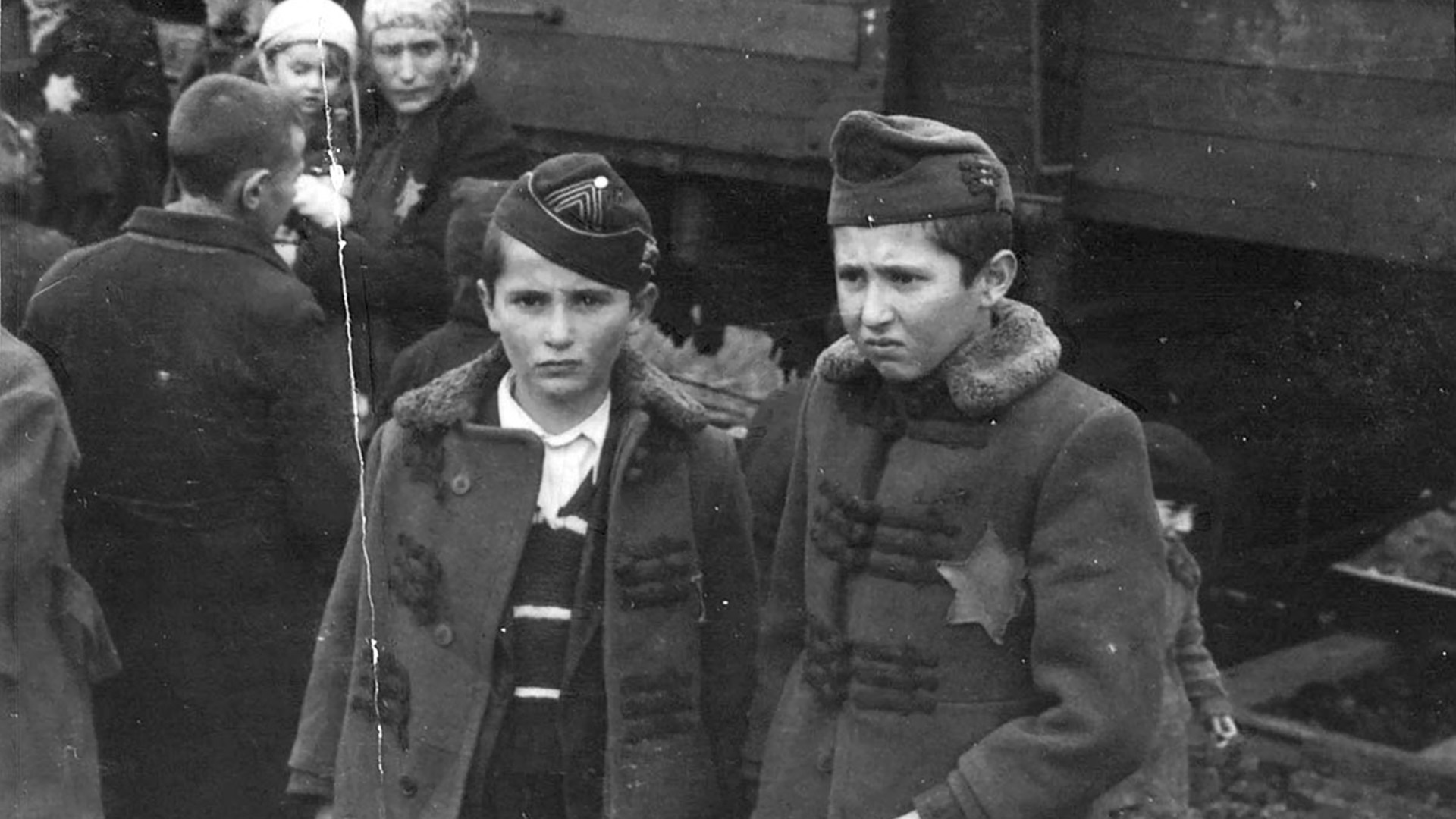 Svartvitt foto av två pojkar med davidsstjärnor fastydda på sina rockar. Den ena tittar allvarligt in i kameran.