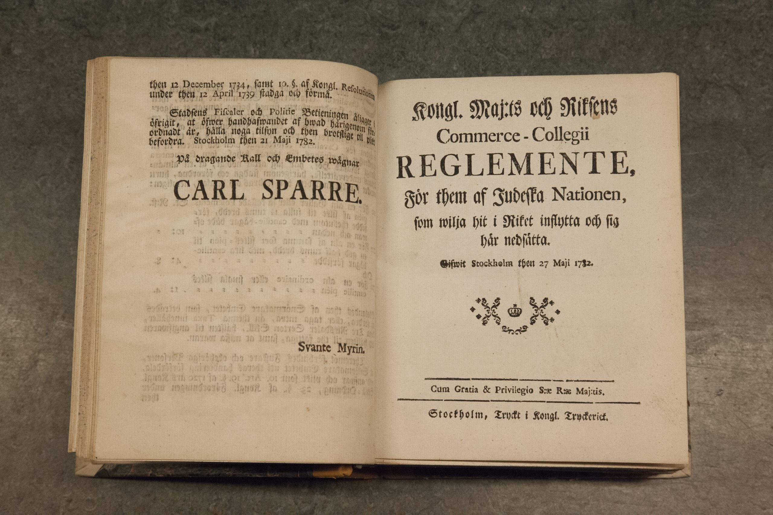 En uppslagen bok med äldre text på gulnat papper. På ena sidan lyder rubriken "Carl Sparre" och på andra sidan "reglemente".