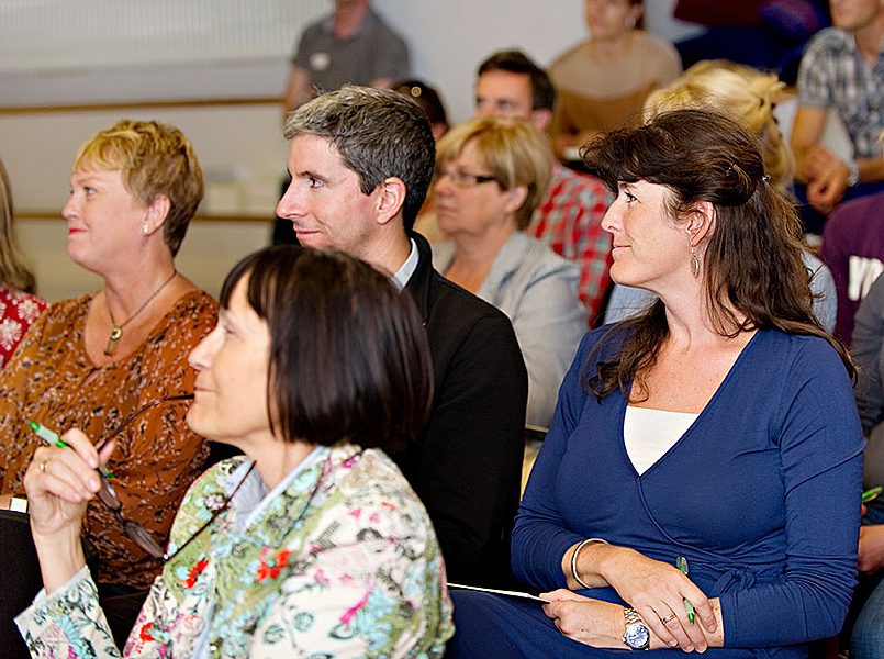 Människor som lyssnar på en talare.